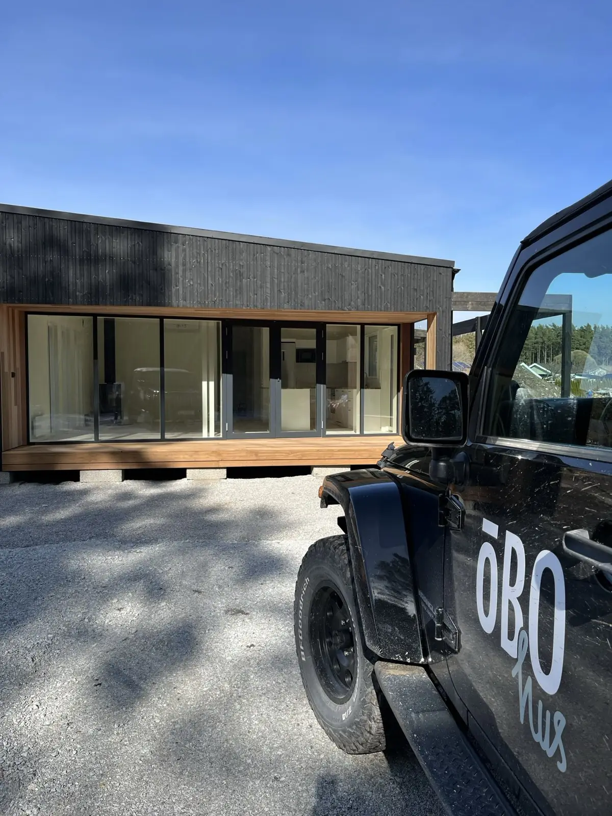 Öbo Hus servicebil framför ett nyligen levererat hus
