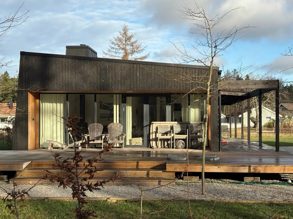 Milo 102 – specialritat hus i mörklaserat trä med pergola och trädäck
